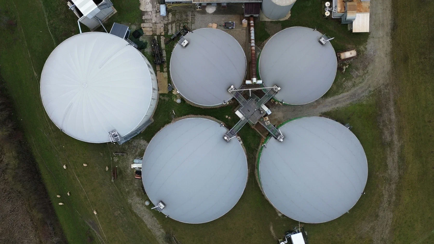 Aerial view of a biogas plant set among green fields